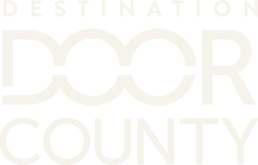 The logo reads "DESTINATION DOOR COUNTY" in white text on a black background. Two Os are linked to look like a chain.